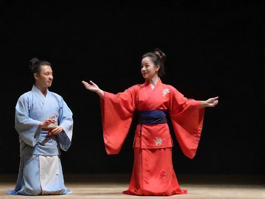 多架色彩鲜艳的航模飞机在开阔的户外草坪上空进行特技飞行表演,背景是蓝天白云,下方有观众在围观。